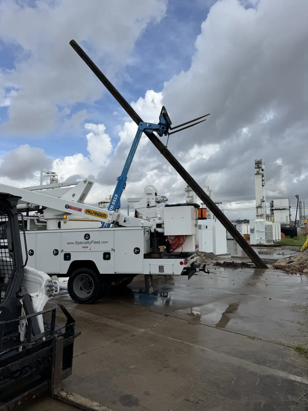 Utility pole being raised next to a bucket truck in La Porte, TX