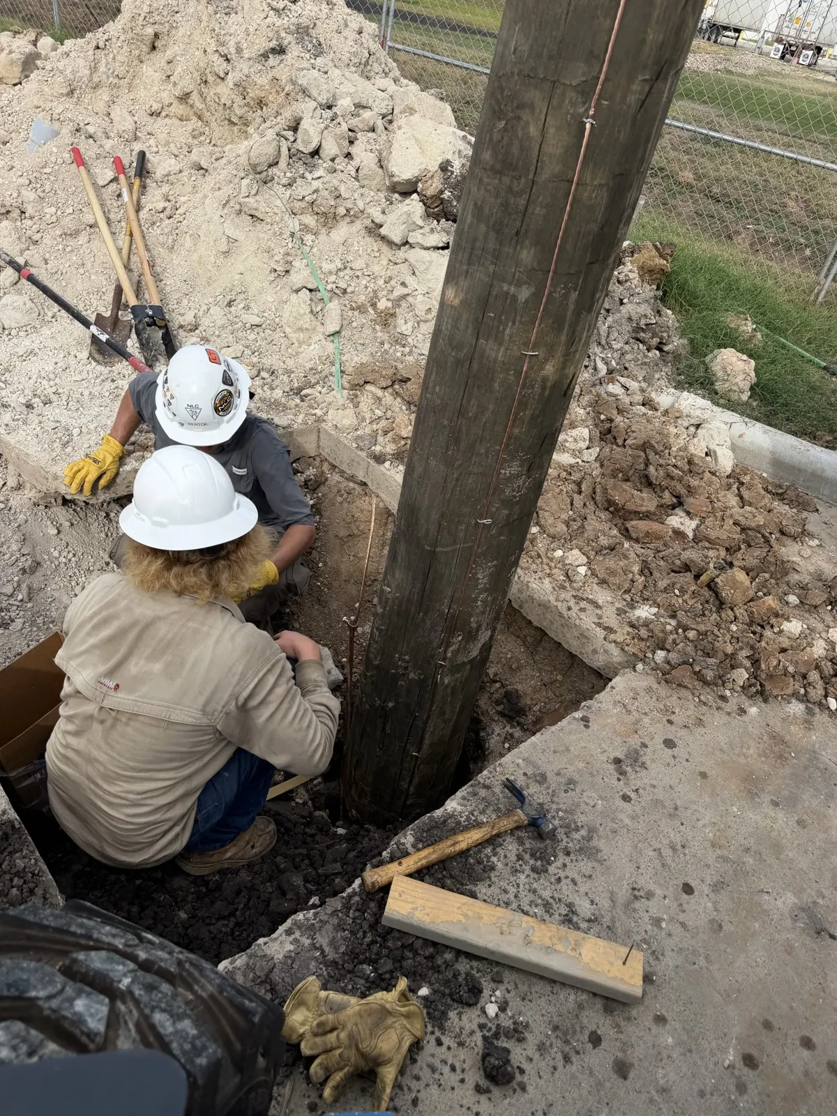 Crew working at the base of a newly set utility pole in La Porte, TX