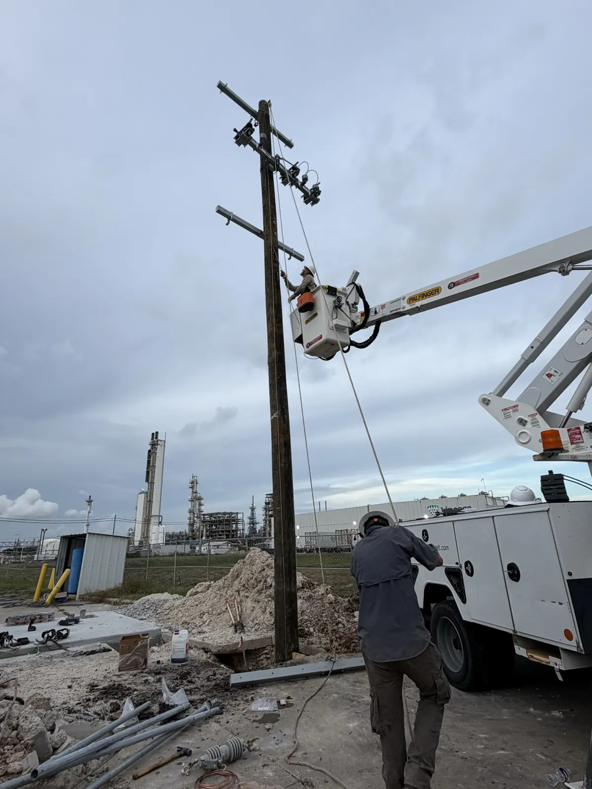 Lineman beside a bucket truck working on a utility pole in La Porte, TX