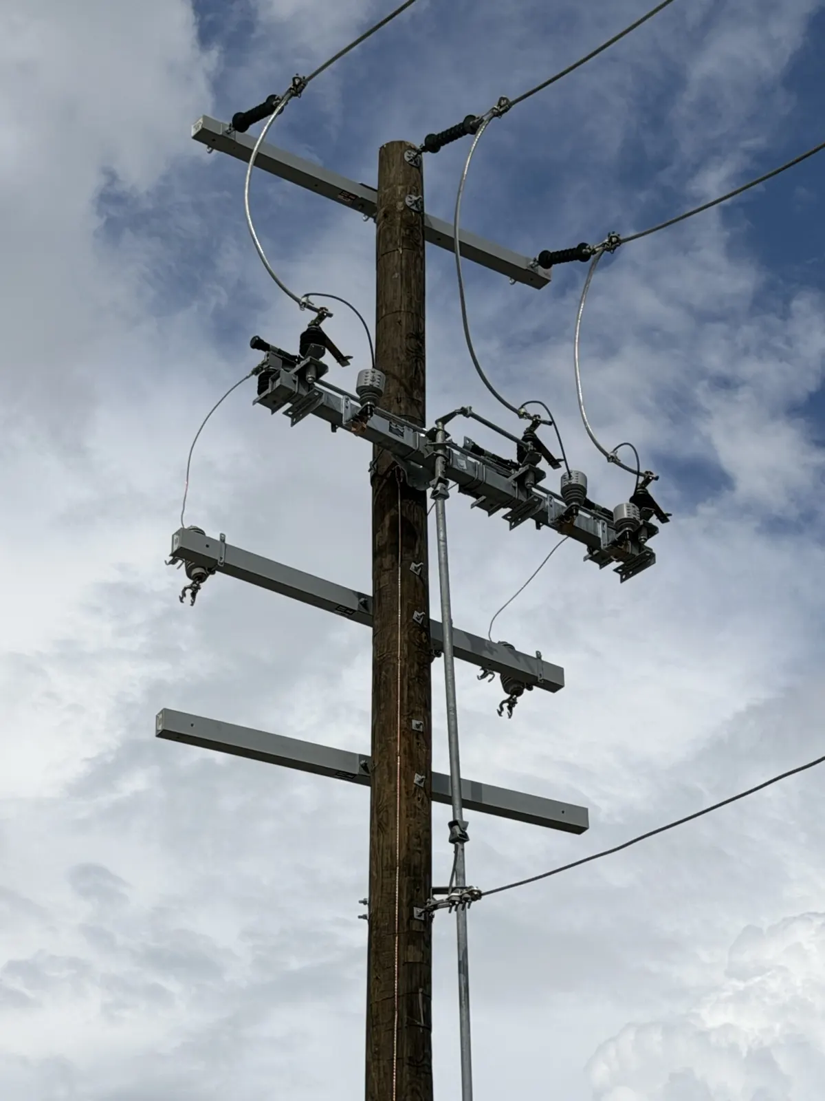 Utility pole with crossarms and line hardware against a cloudy sky in La Porte, TX