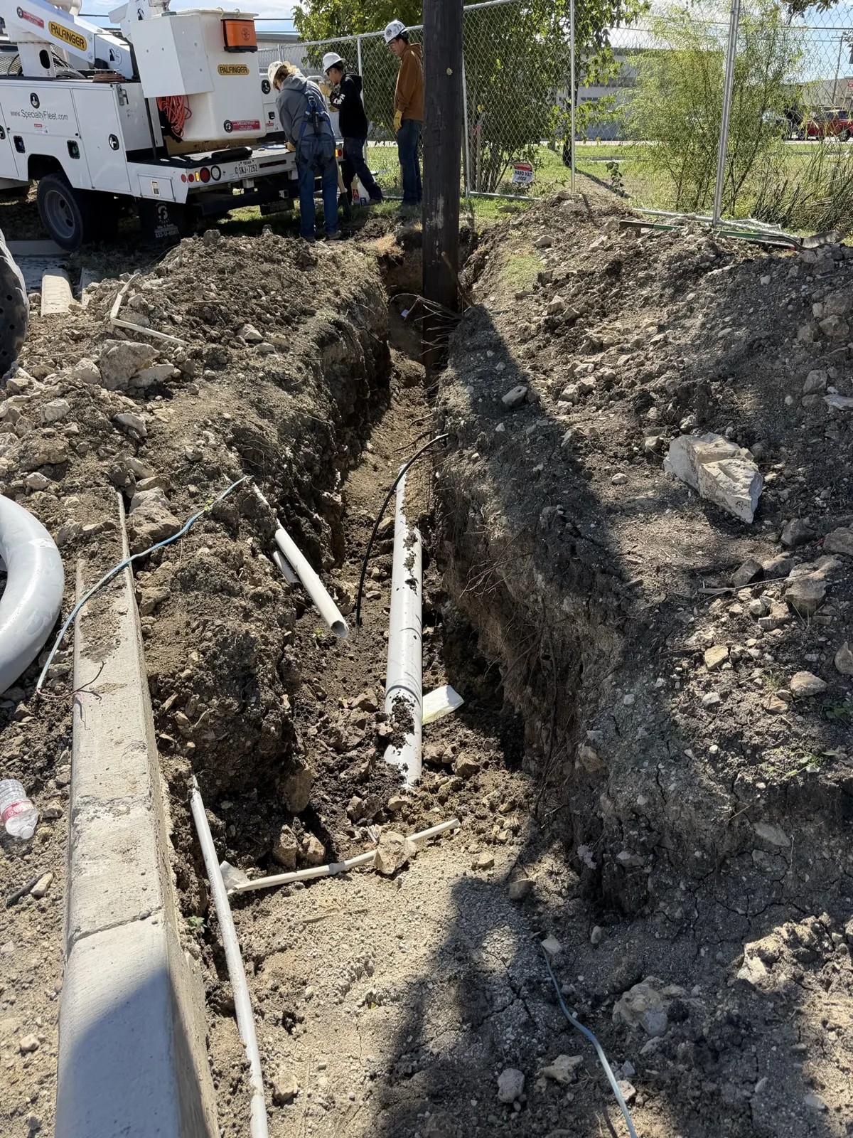 Open trench with underground conduit runs next to a utility pole in Saginaw, TX