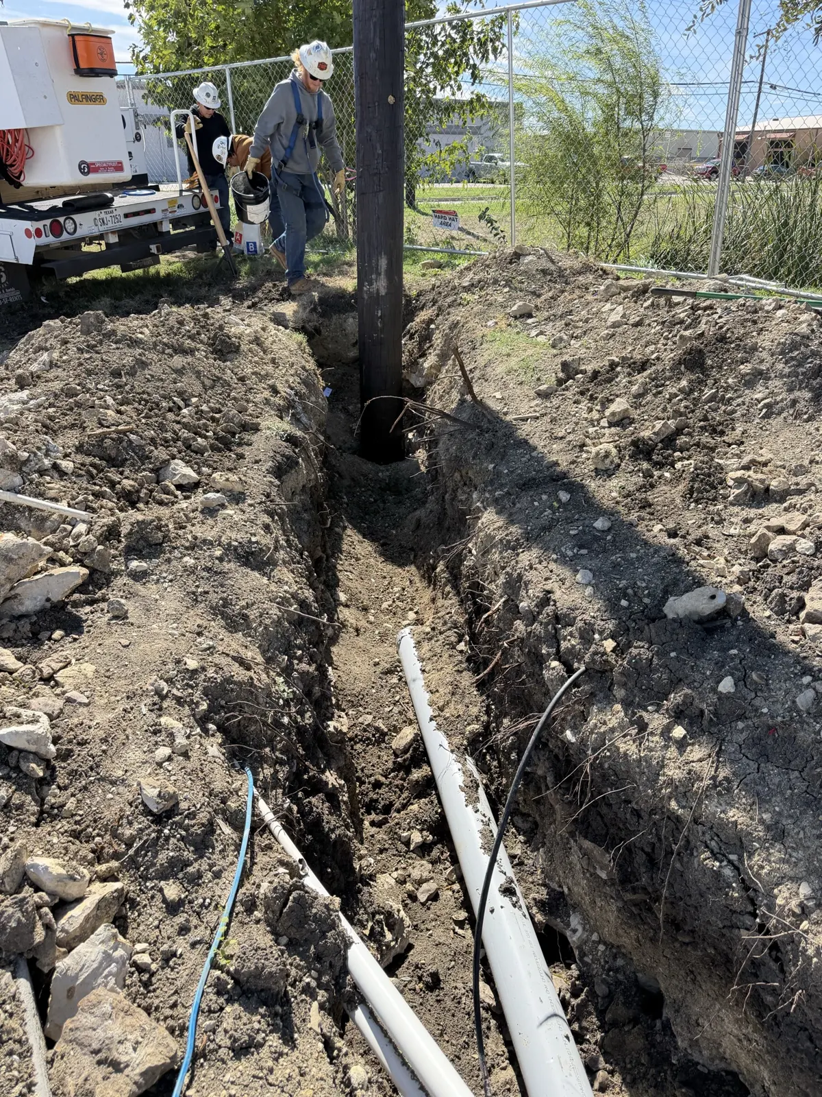 New utility pole base in a trench with conduit at a Saginaw, TX Tesla charging station project